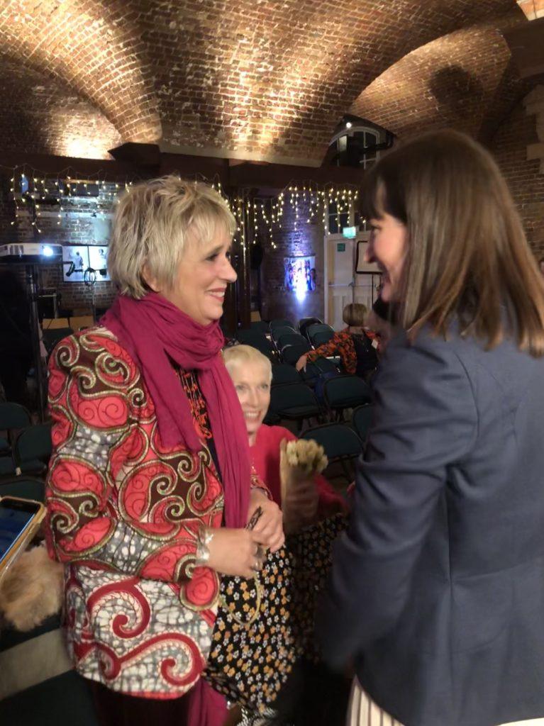 Womens tailor Dara Ford speaking to Eve Ensler and Annie Lennox and gifting them silk scarves from her own collection