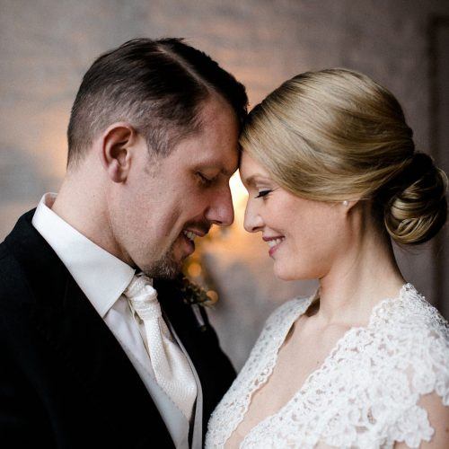 Wedding picture of Victoria and Thorsten, a white couple. The bride is wearing a white Lace wedding dress and the groom a black jacket with white shirt and tie