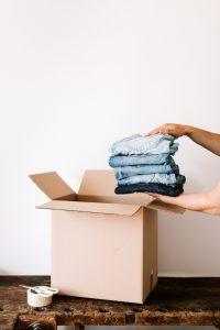 Stack of jeans being put into a cardboard box