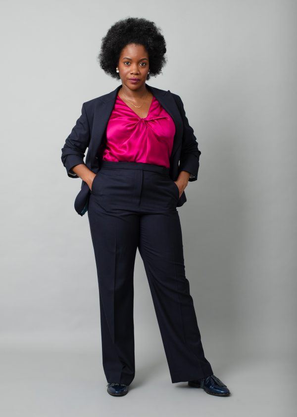 Black woman modelling a navy suit and berry pink silk blouse.