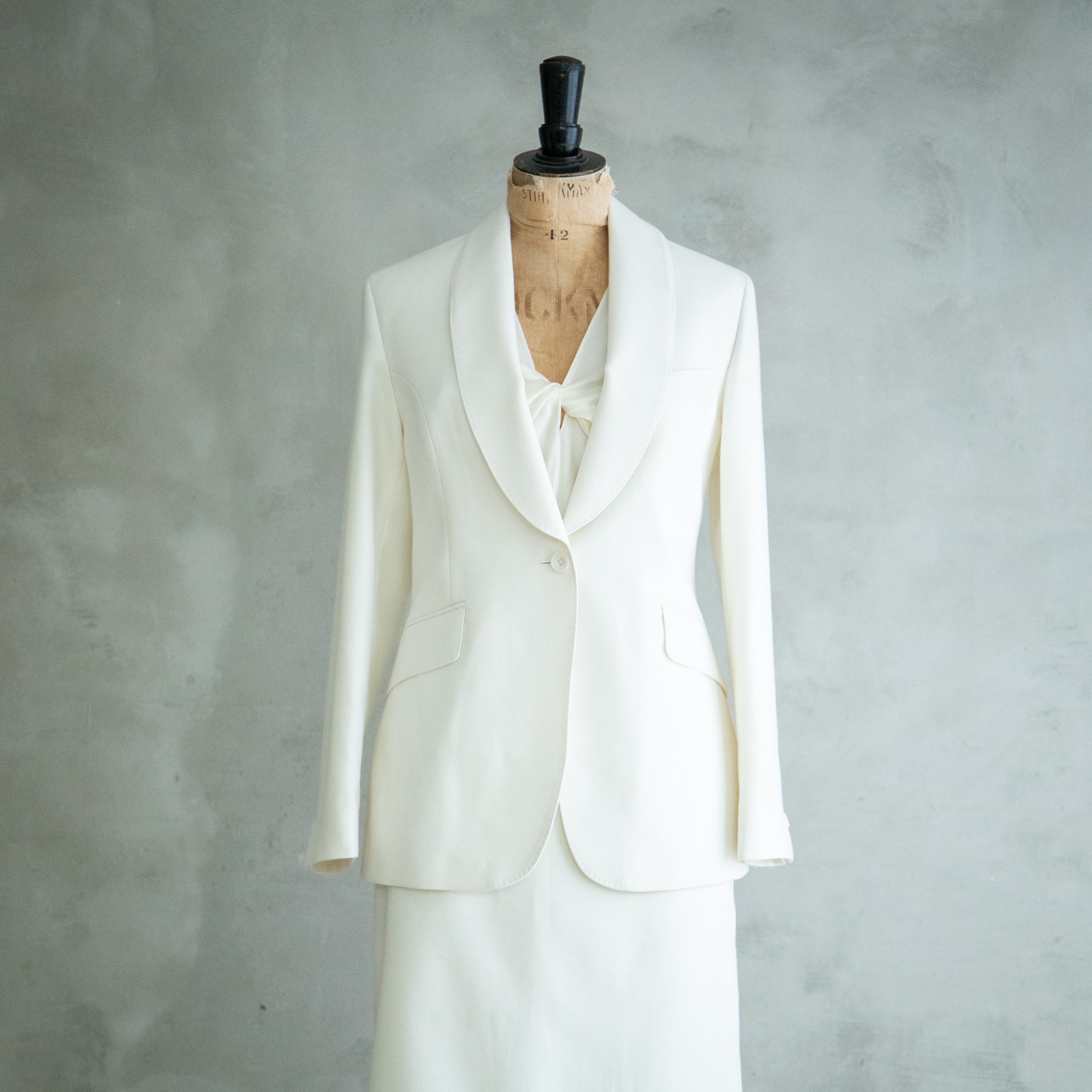 a cream tailored jacket, blouse and skirt on a dressmakers dummy