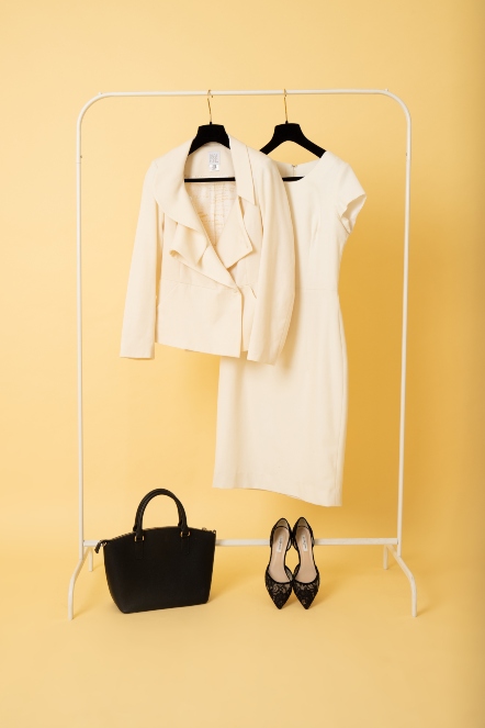 Cream dress and matching jacket with black shoes and bag wedding outfit idea