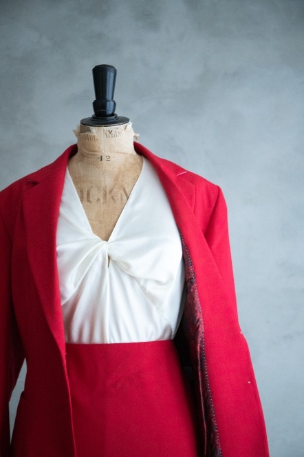 Womens red skirt suit and cream silk blouse on a dressmakers dummy