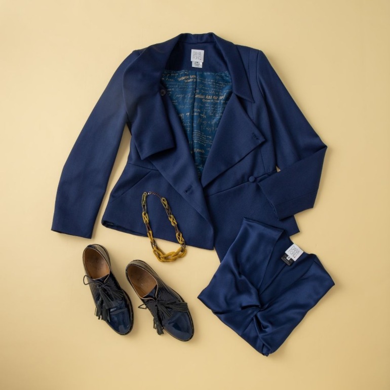 Flat lay of navy tailored jacket and camisole with brogue shoes and chunky tortoiseshell necklace